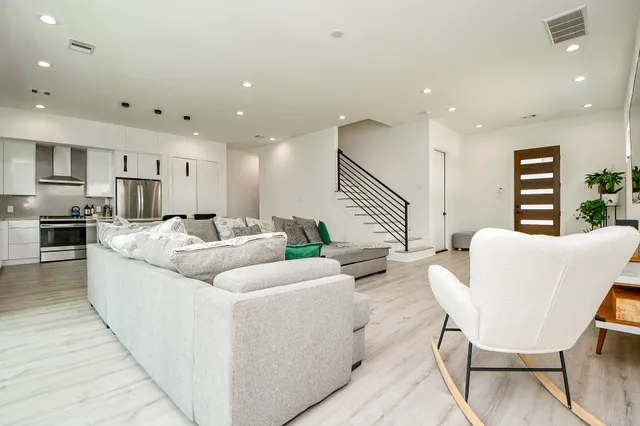 a living room with furniture kitchen and a table