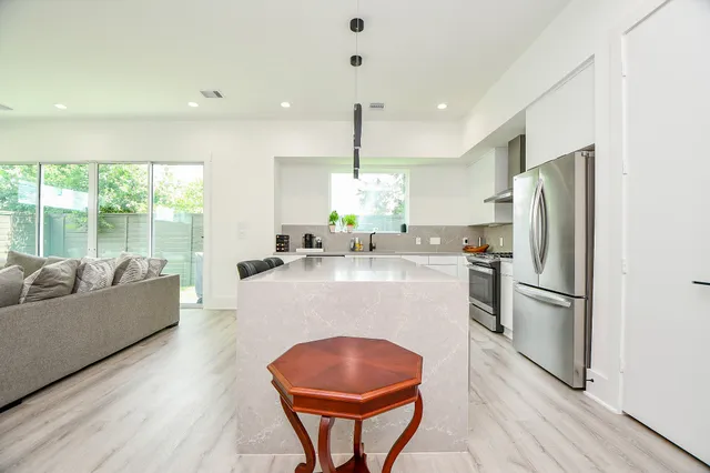 a kitchen with kitchen island a counter top space cabinets stainless steel appliances and a large window