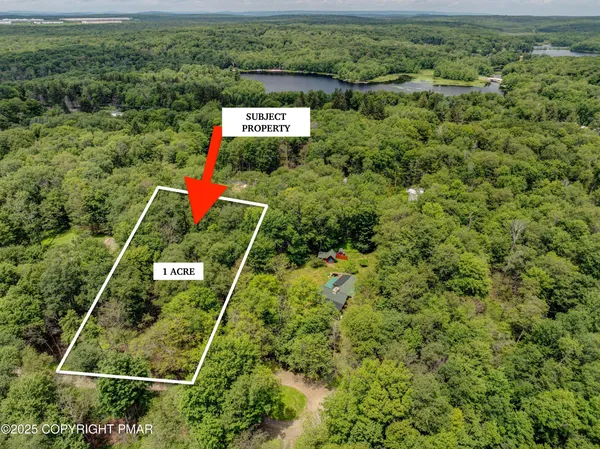 an aerial view of a residential houses with yard and ocean view