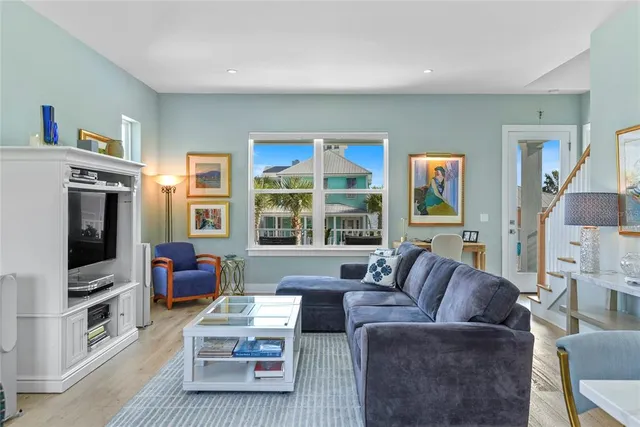 a living room with furniture a flat screen tv and a large window