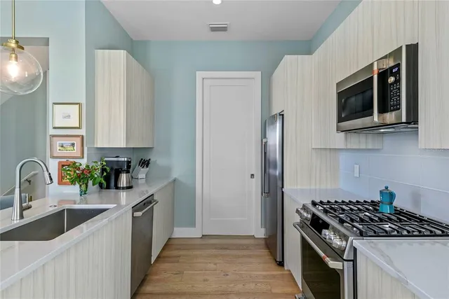 a kitchen with stainless steel appliances a sink stove and refrigerator
