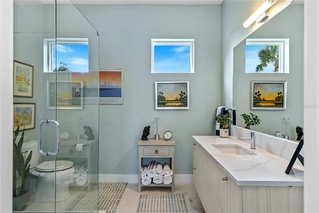 a bathroom with a sink a toilet and shower