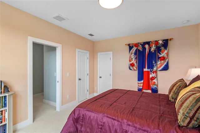 a bedroom with a bed and a painting on the wall