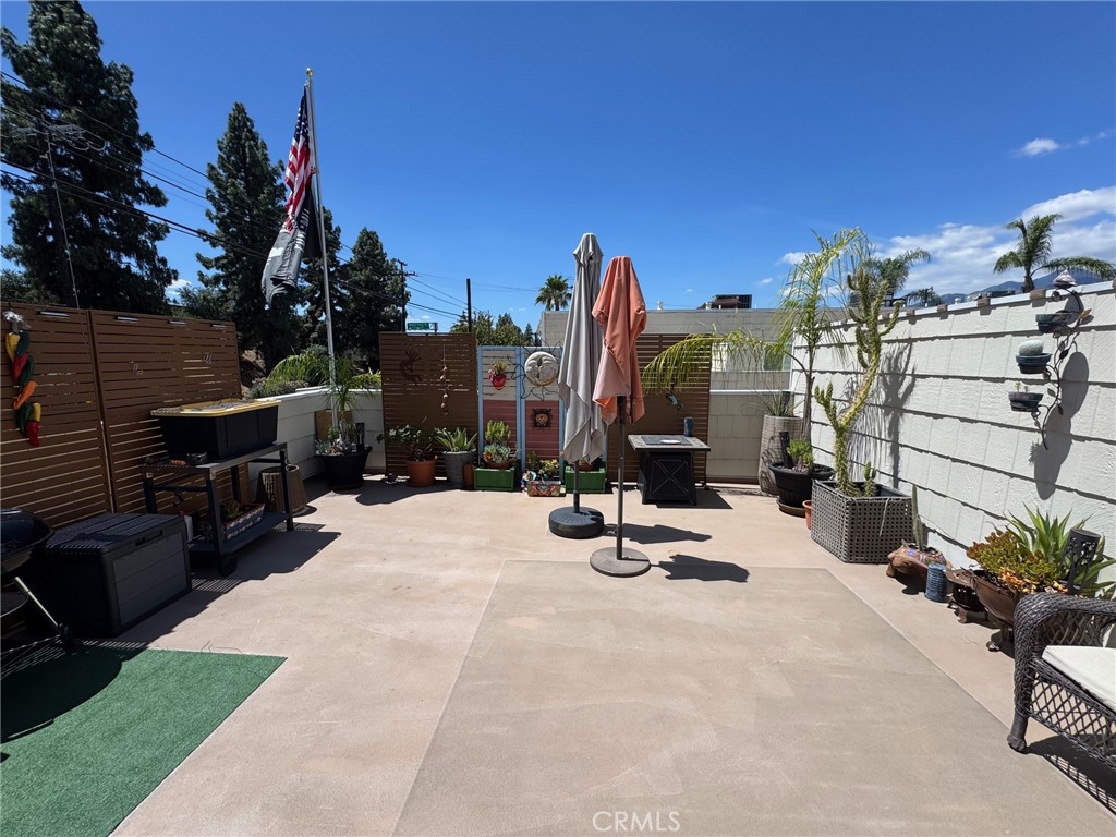 1434 Highland Avenue, Unit 13 Duarte, CA 91010 - Photo 13 of 14 a view of a patio with a table and chairs under an umbrella