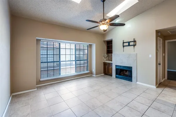 a view of an empty room with a fireplace and a window