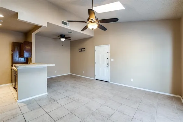 a view of an empty room and a ceiling fan