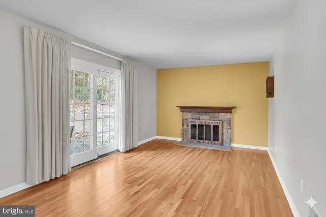 a view of an empty room with a window and fireplace