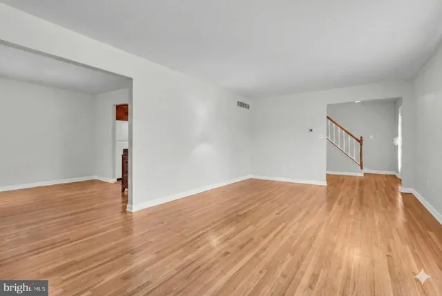a view of empty room with wooden floor