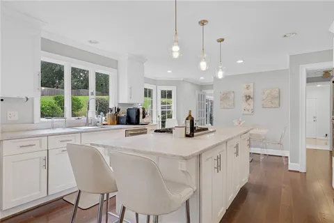 a kitchen with stainless steel appliances granite countertop a sink a stove a refrigerator and island with wooden floor