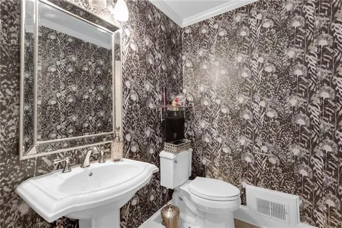 a bathroom with a toilet sink and mirror