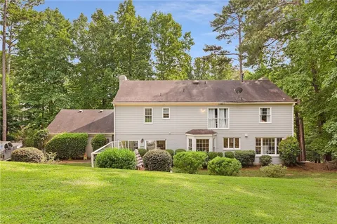 a aerial view of a house next to a big yard and large trees