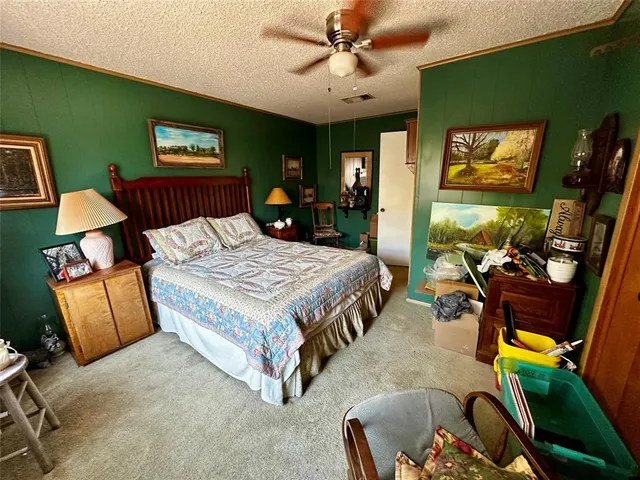 a bedroom with a bed a couch and dresser