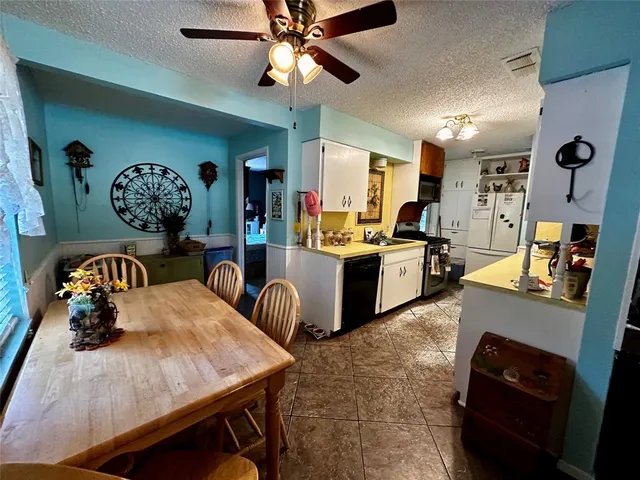 a large kitchen with a table chairs and a refrigerator