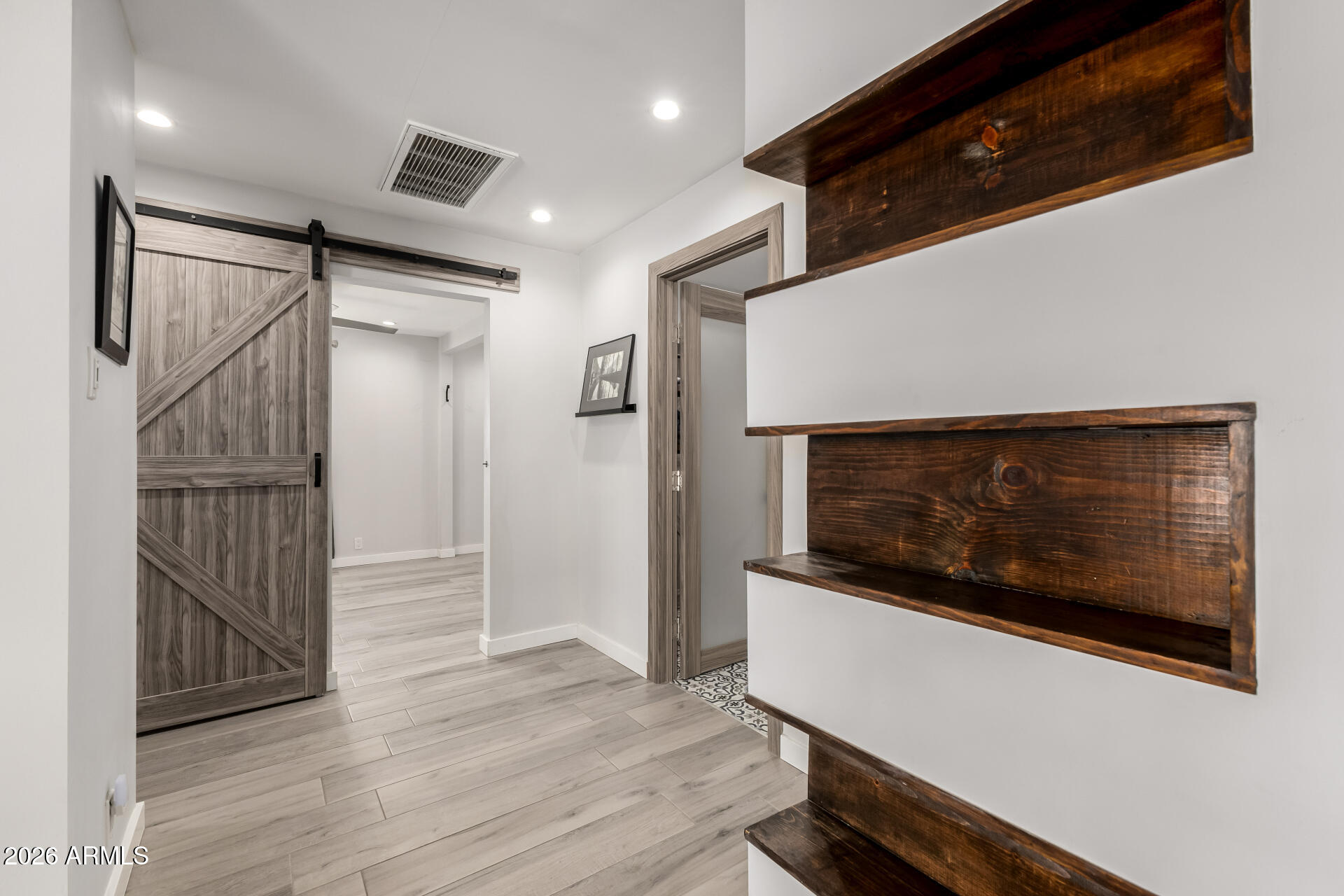 2402 North 37th Street Phoenix, AZ 85008 - Photo 22 of 44 a view of an empty room with wooden floor and a kitchen