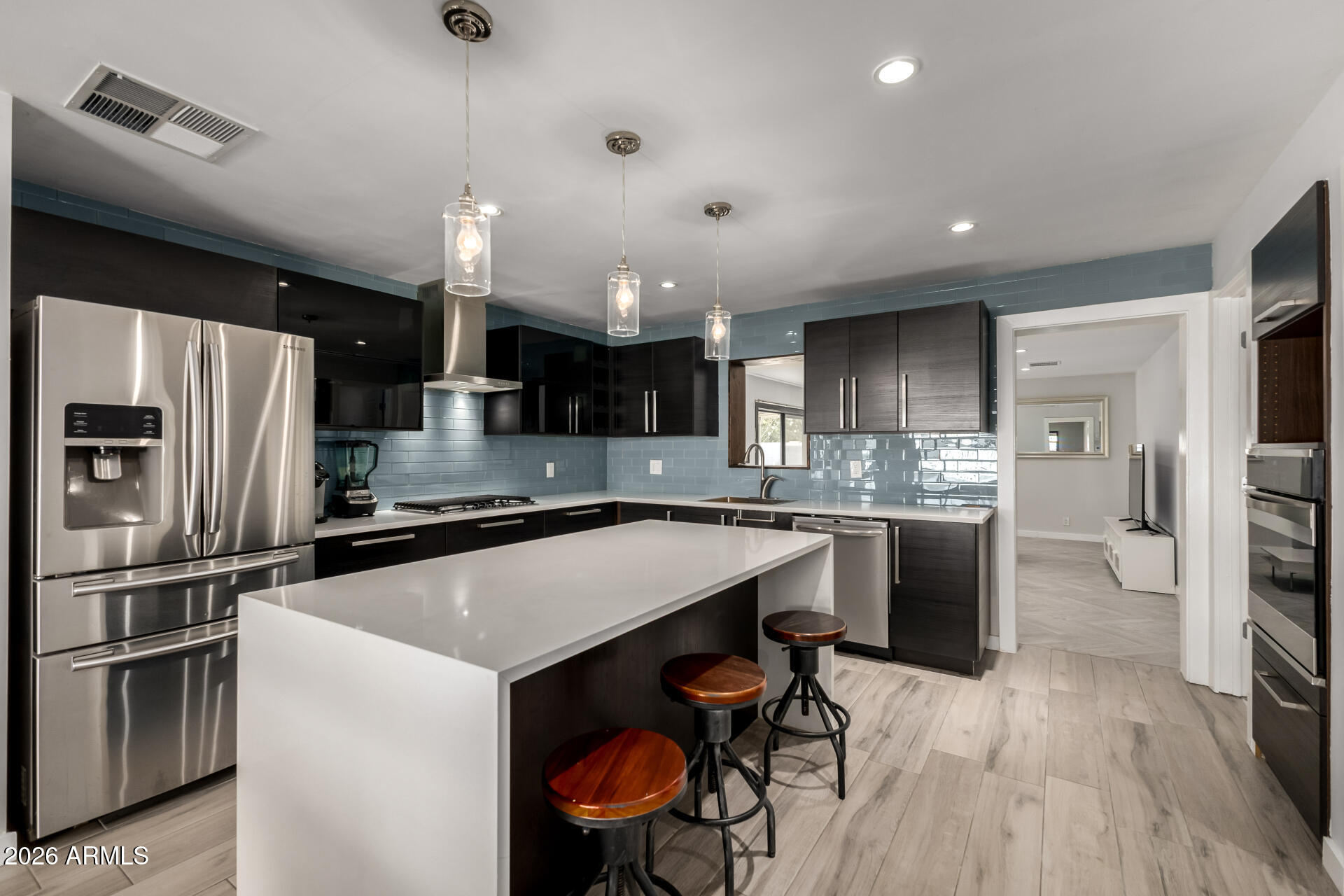 2402 North 37th Street Phoenix, AZ 85008 - Photo 9 of 44 a kitchen with a center island wooden floor and stainless steel appliances