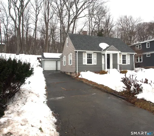 a front view of a house with a yard covered with trees