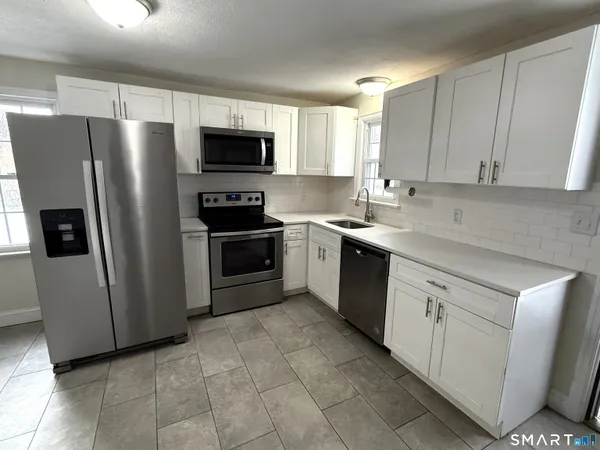 a kitchen with stainless steel appliances a refrigerator sink and microwave