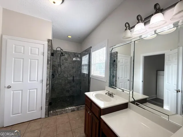 a bathroom with a sink a shower and a mirror