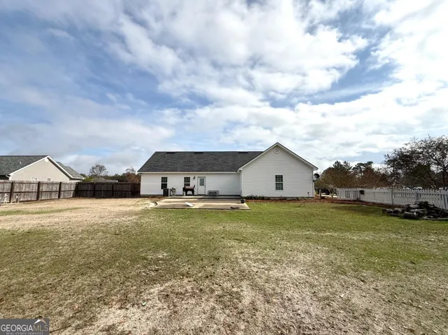 a view of a big yard with a house in the background
