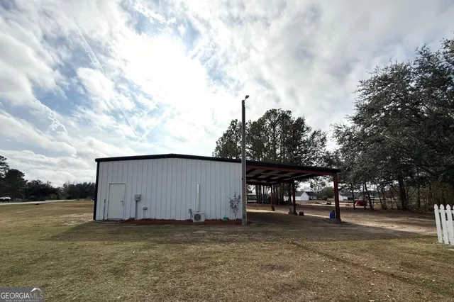 a view of large house with a big yard and large trees