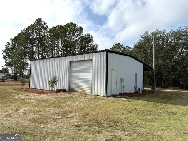 a view of a house with backyard and trees