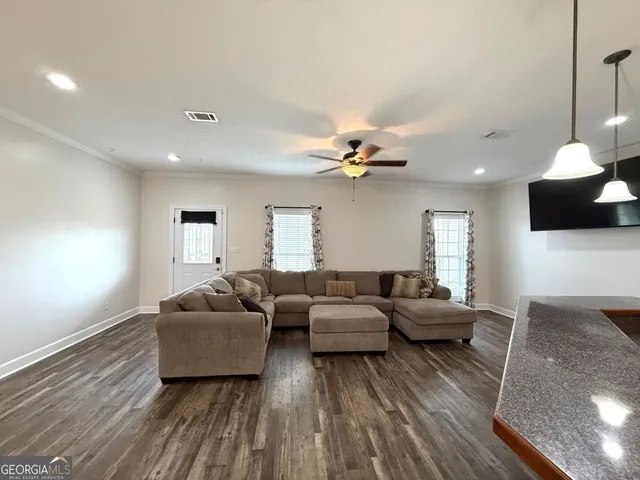 a living room with furniture and a wooden floor