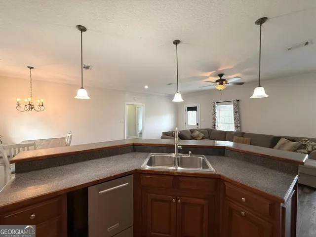a kitchen with a sink and chandelier