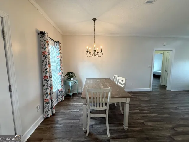 a view of a dining room with furniture wooden floor and chandelier
