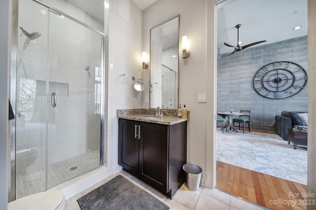 2116 McClintock Road, Unit 122 Charlotte, NC 28205 - Photo 16 of 27 a bathroom with a granite countertop sink a toilet and shower