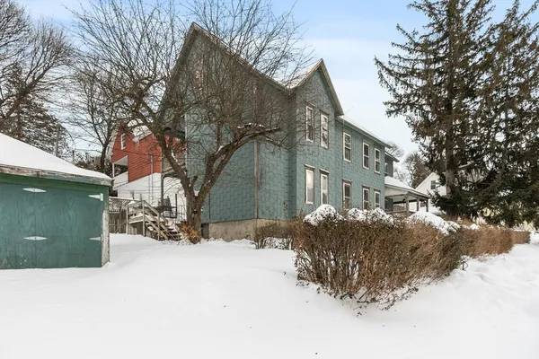 a view of a house with a yard covered in snow