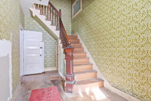 a view of staircase with wooden floor and white walls