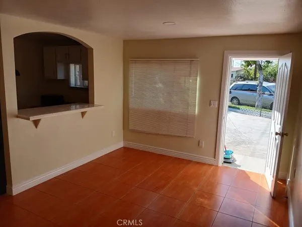 a view of an empty room with window and bathroom
