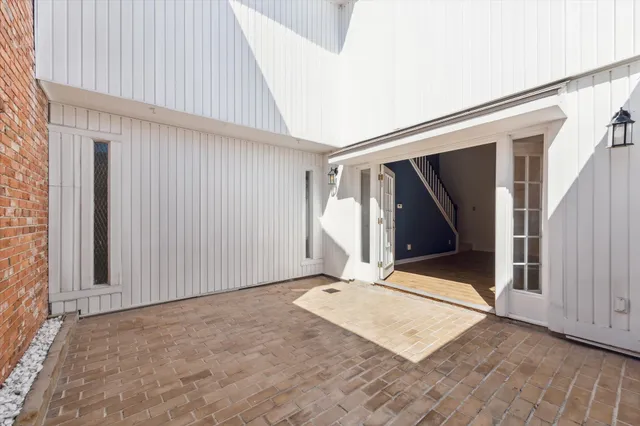 a view of an empty room with wooden floor and entryway