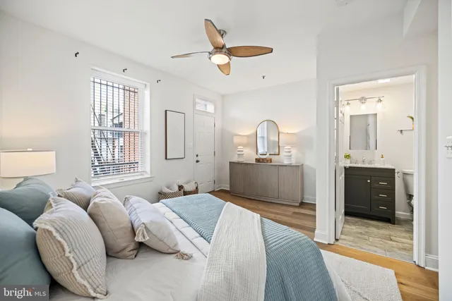 a spacious bedroom with a large bed and ceiling fan