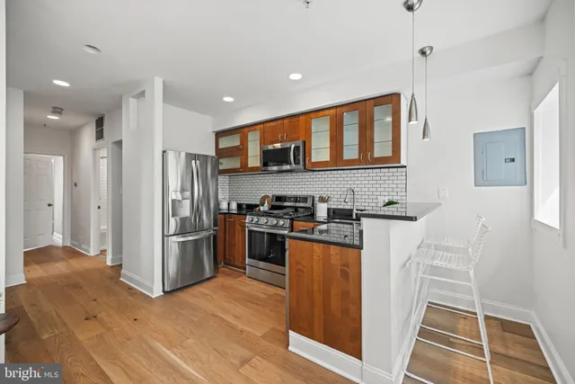 a kitchen with stainless steel appliances granite countertop a refrigerator a stove and a sink