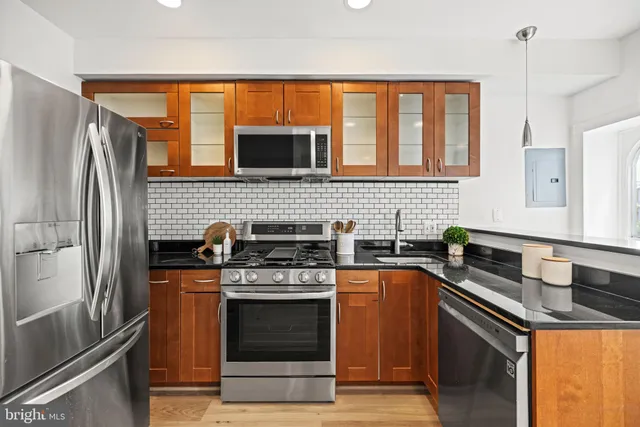 a kitchen with stainless steel appliances granite countertop a stove a sink and a refrigerator