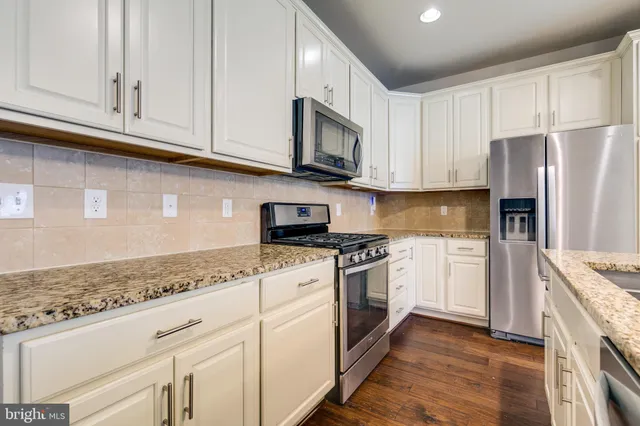 a kitchen with granite countertop cabinets stainless steel appliances and a sink