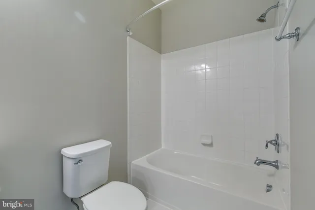 a white toilet sitting next to a bath tub