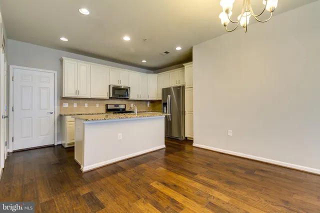 a kitchen with granite countertop white cabinets and stainless steel appliances