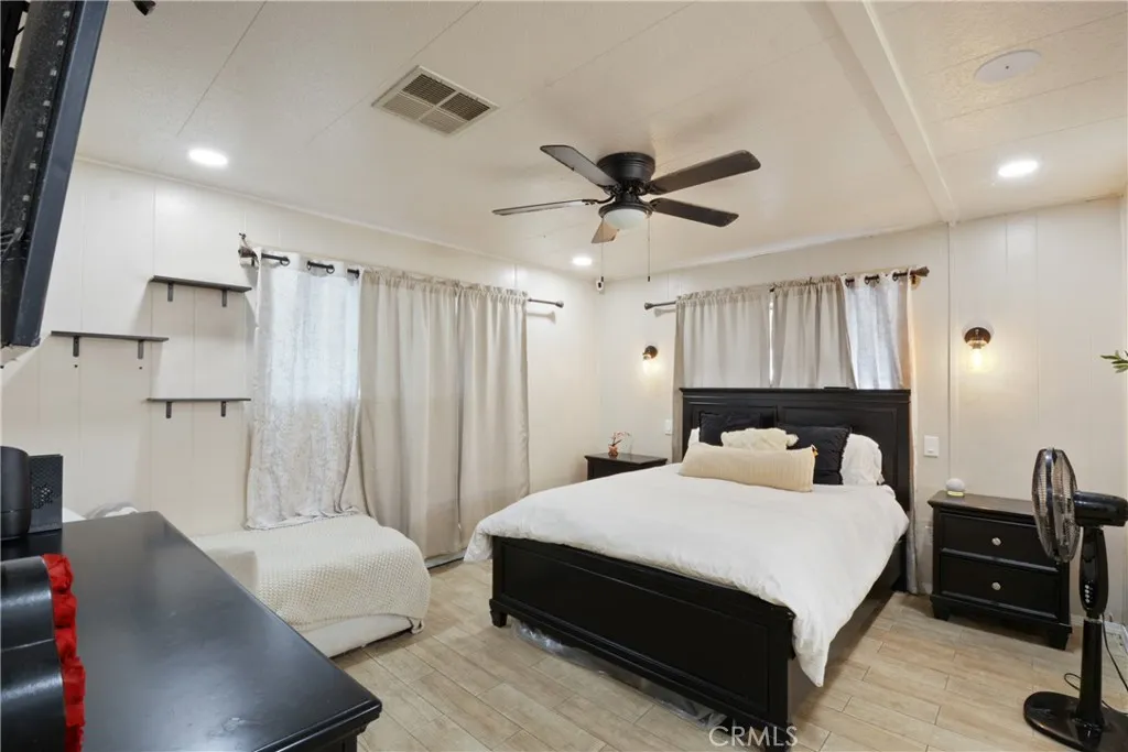 23701 South Western Avenue, Unit 197 Torrance, CA 90501 - Photo 19 of 32 a bedroom with a bed a couch and a chandelier