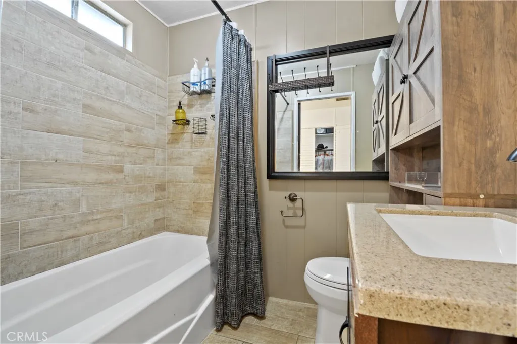 23701 South Western Avenue, Unit 197 Torrance, CA 90501 - Photo 23 of 32 a bathroom with a granite countertop bathtub shower sink mirror and toilet