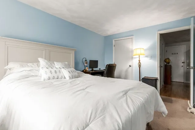 a large bed sitting in a bedroom and a lamp