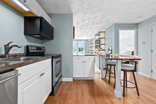 a kitchen with a sink cabinets and wooden floor