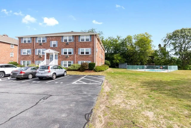 a view of building with cars parked in front of it