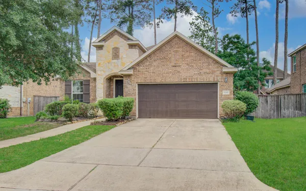 a front view of a house with a yard and trees