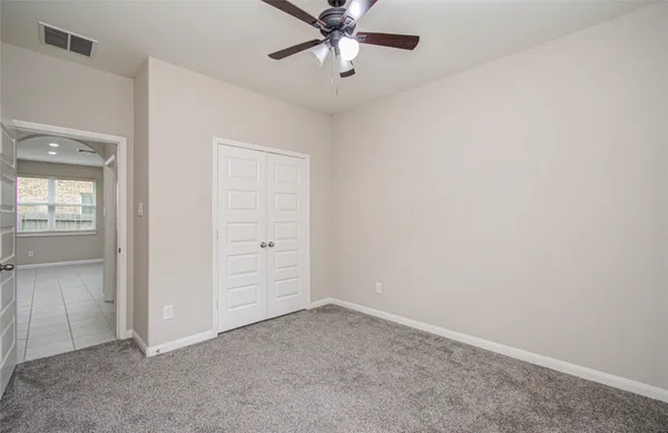an empty room with a window and a fan