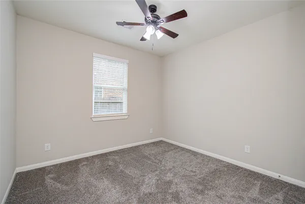 an empty room with closet and fan