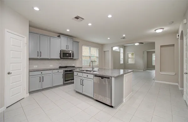 a kitchen with stainless steel appliances granite countertop a sink and cabinets