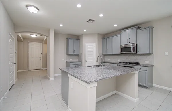 a kitchen with stainless steel appliances granite countertop a sink and a stove