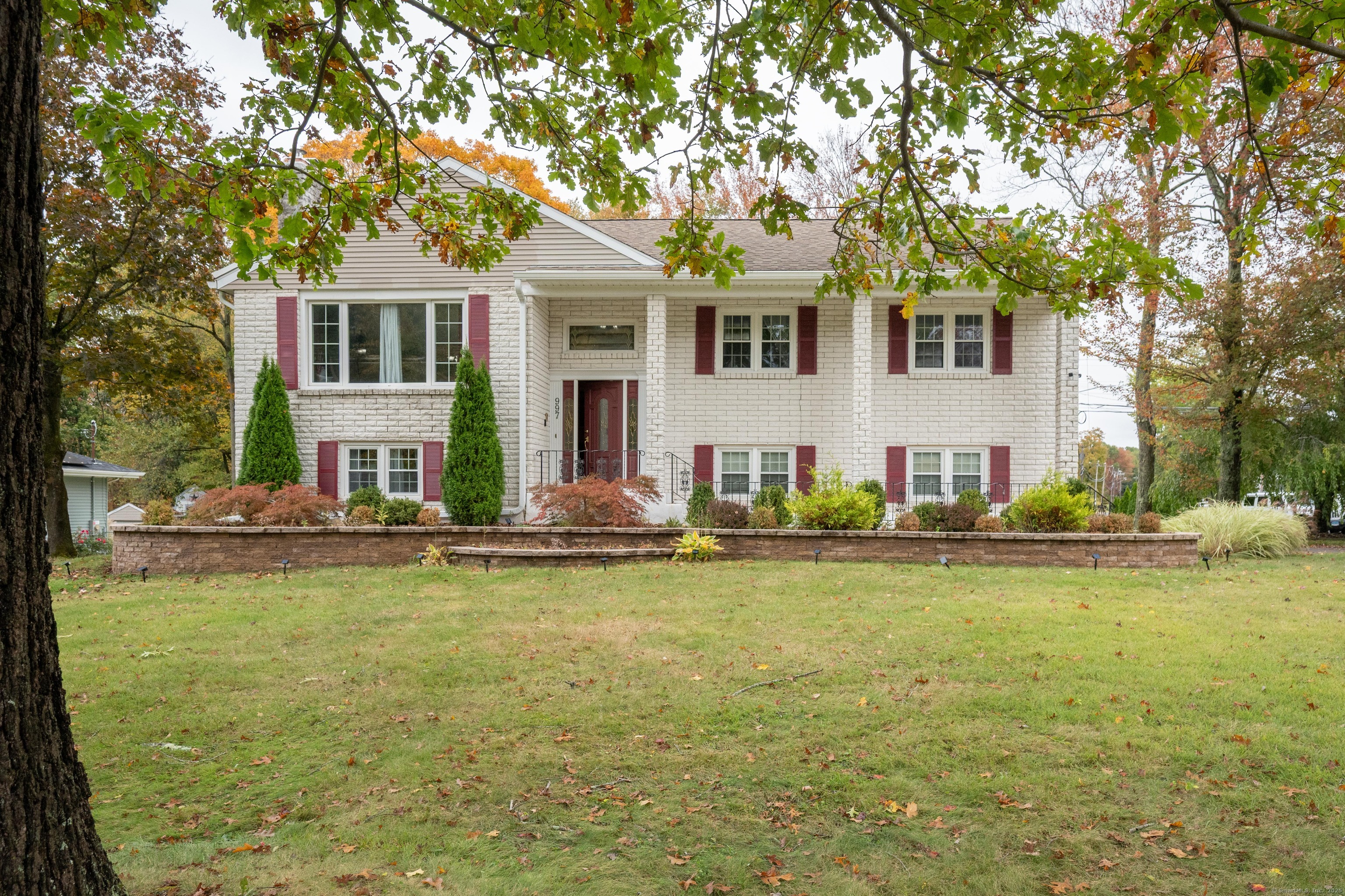 a view of a white house with a large pool and large trees